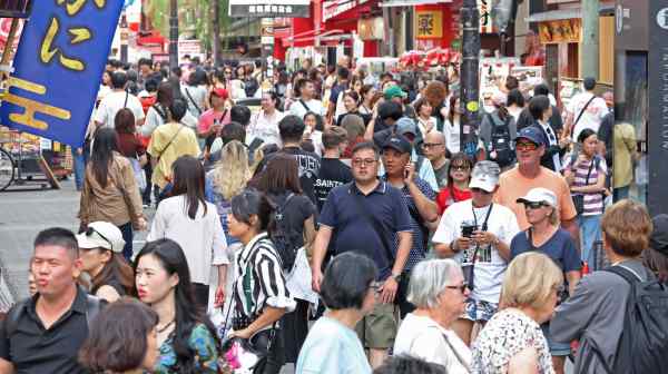 Tourists pack the streets of Dotonbori, Osaka's canal-side entertainment district, in October 2025. (Photo by Akitoshi Sugiura)